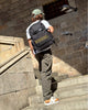 A man with a backpack climbing stairs.