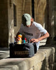 Man sitting on stone wall with cooler, enjoying a sunny day outdoors